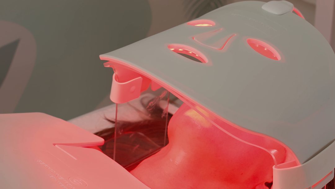 A client resting under a softly glowing LED light mask